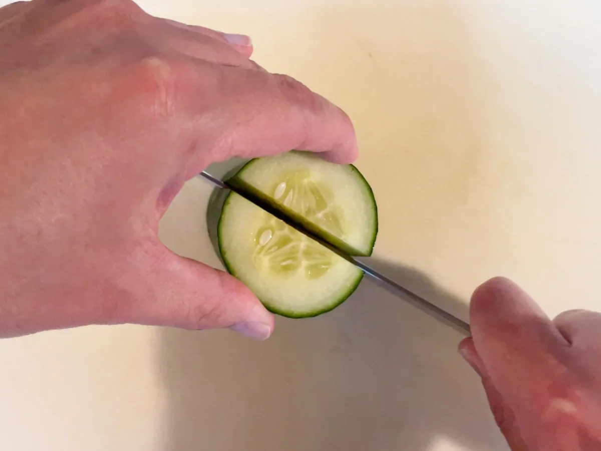 A cucumber being halved lengthways