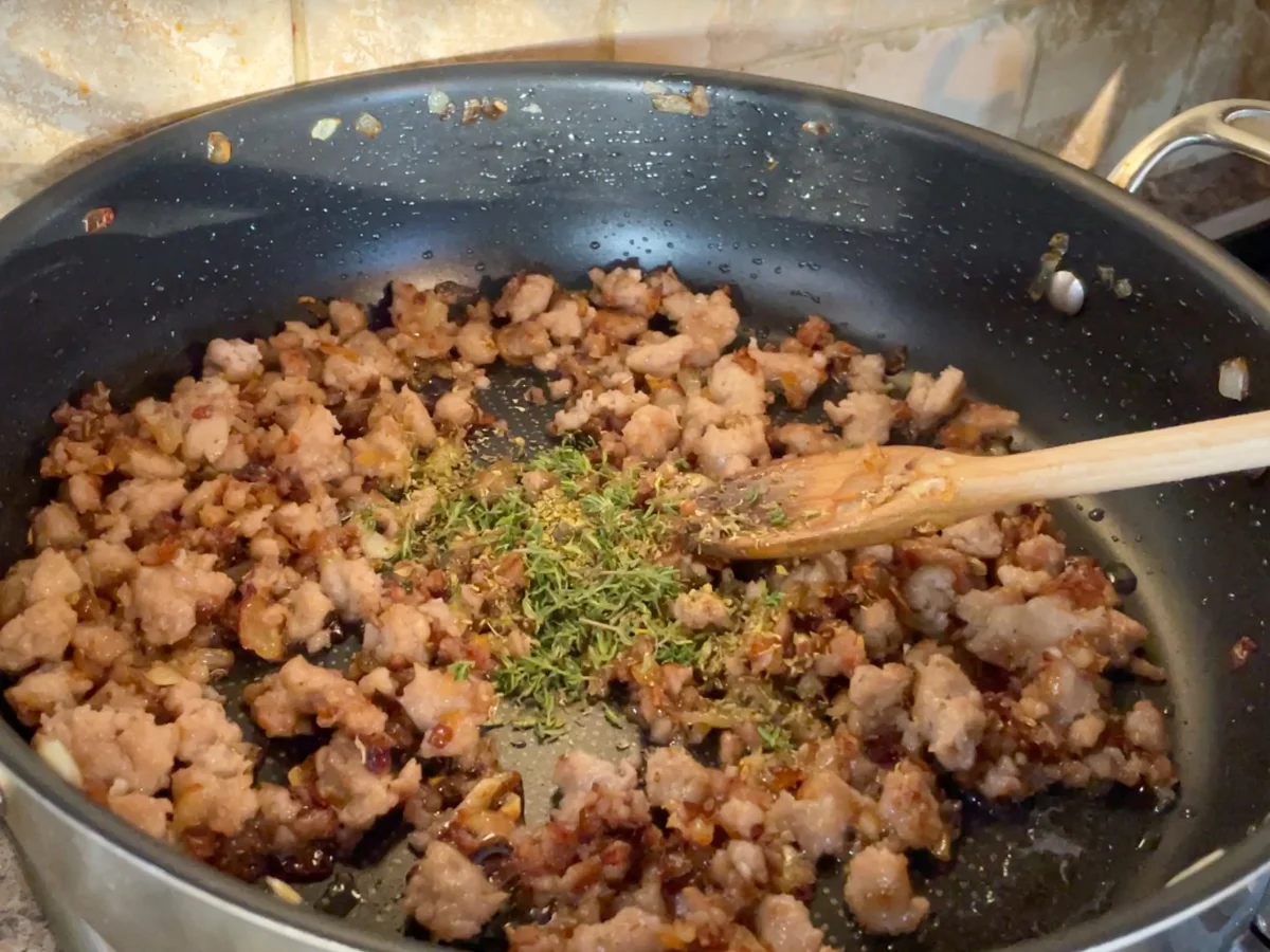 Adding aromatics to the sausage, tomato and mascarpone pasta