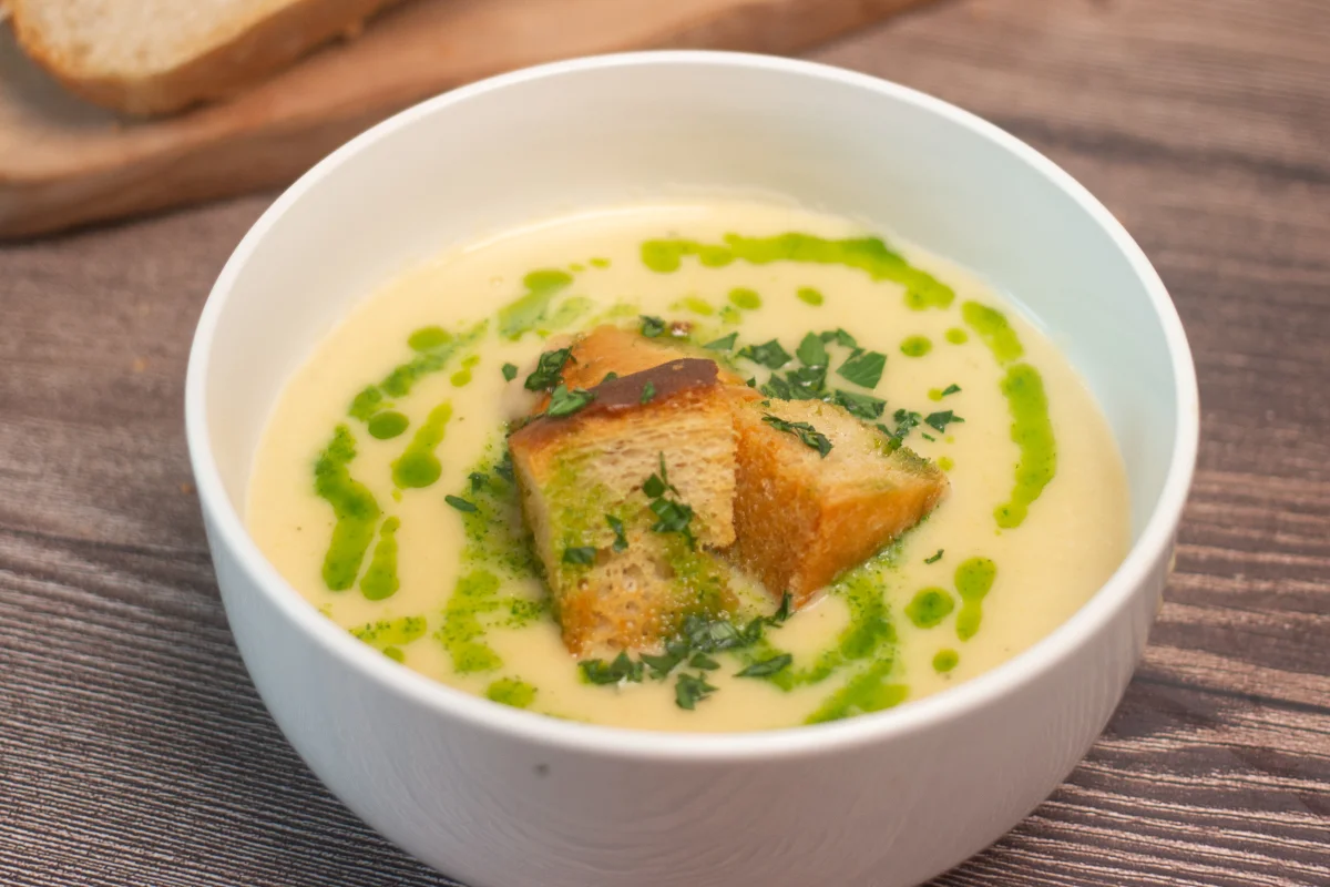 Creamy leek and potato soup topped with chunky croutons and drizzled with parsley oil
