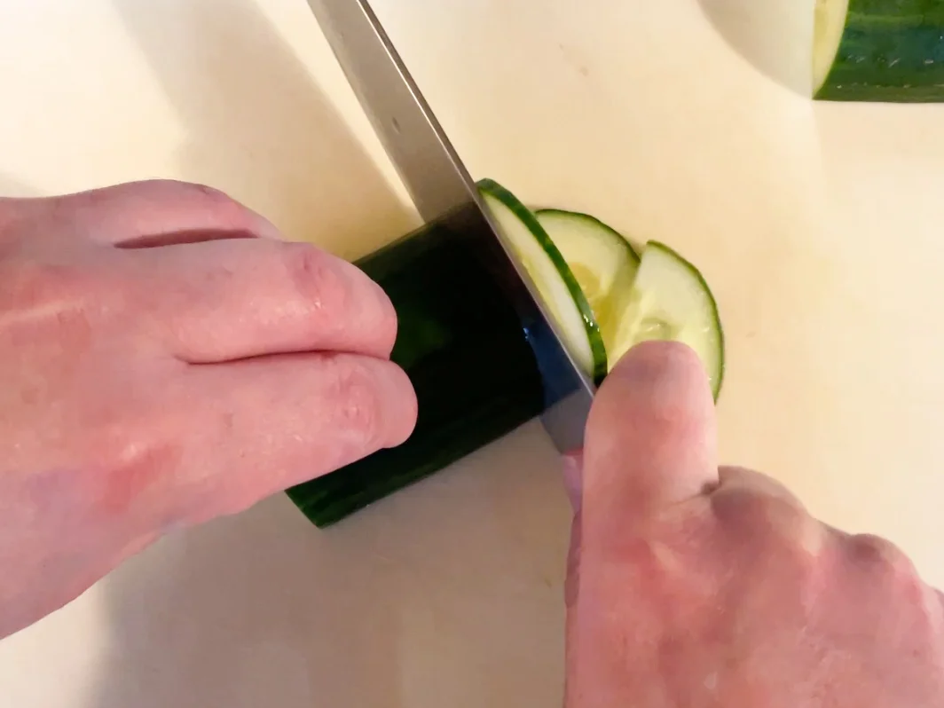 Cutting cucumber into slices.