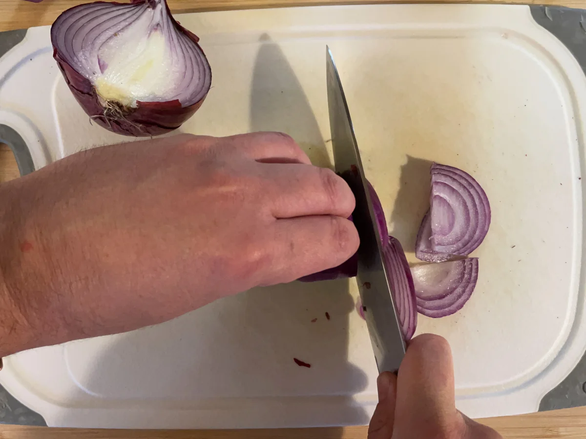 Cutting red onion from root to tip