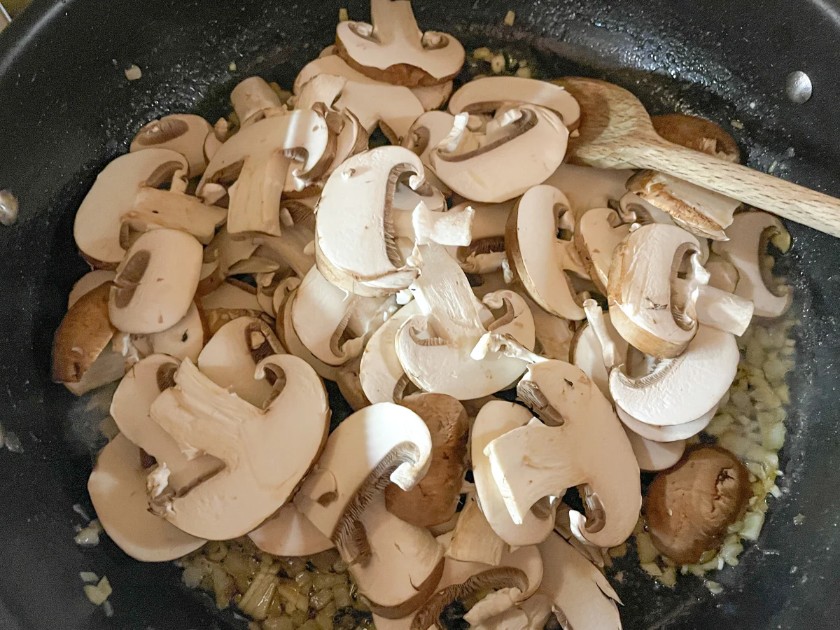Mushrooms and garlic added to the pan with the onion