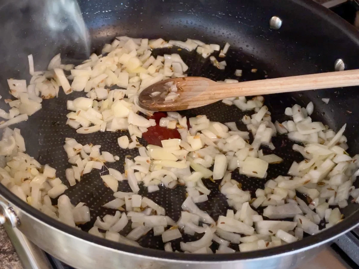Onions, garlic and fennel seeds being sauteed