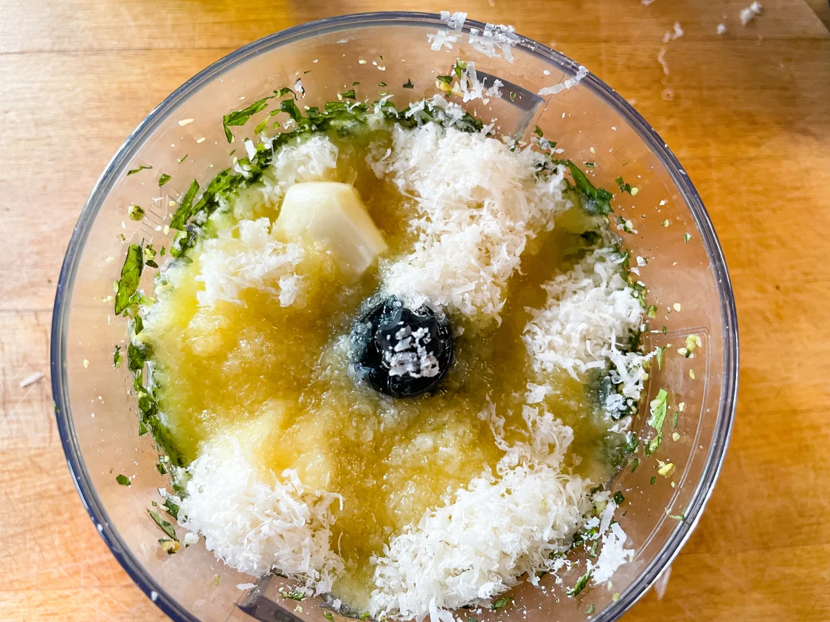 Parmesan, olive oil and garlic added to the pesto in a food processor