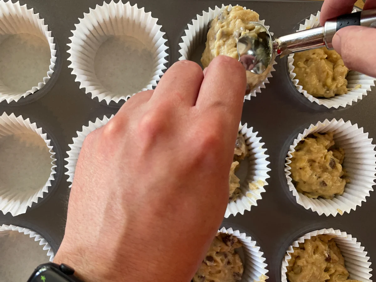 Scooping the muffin batter into muffin cases