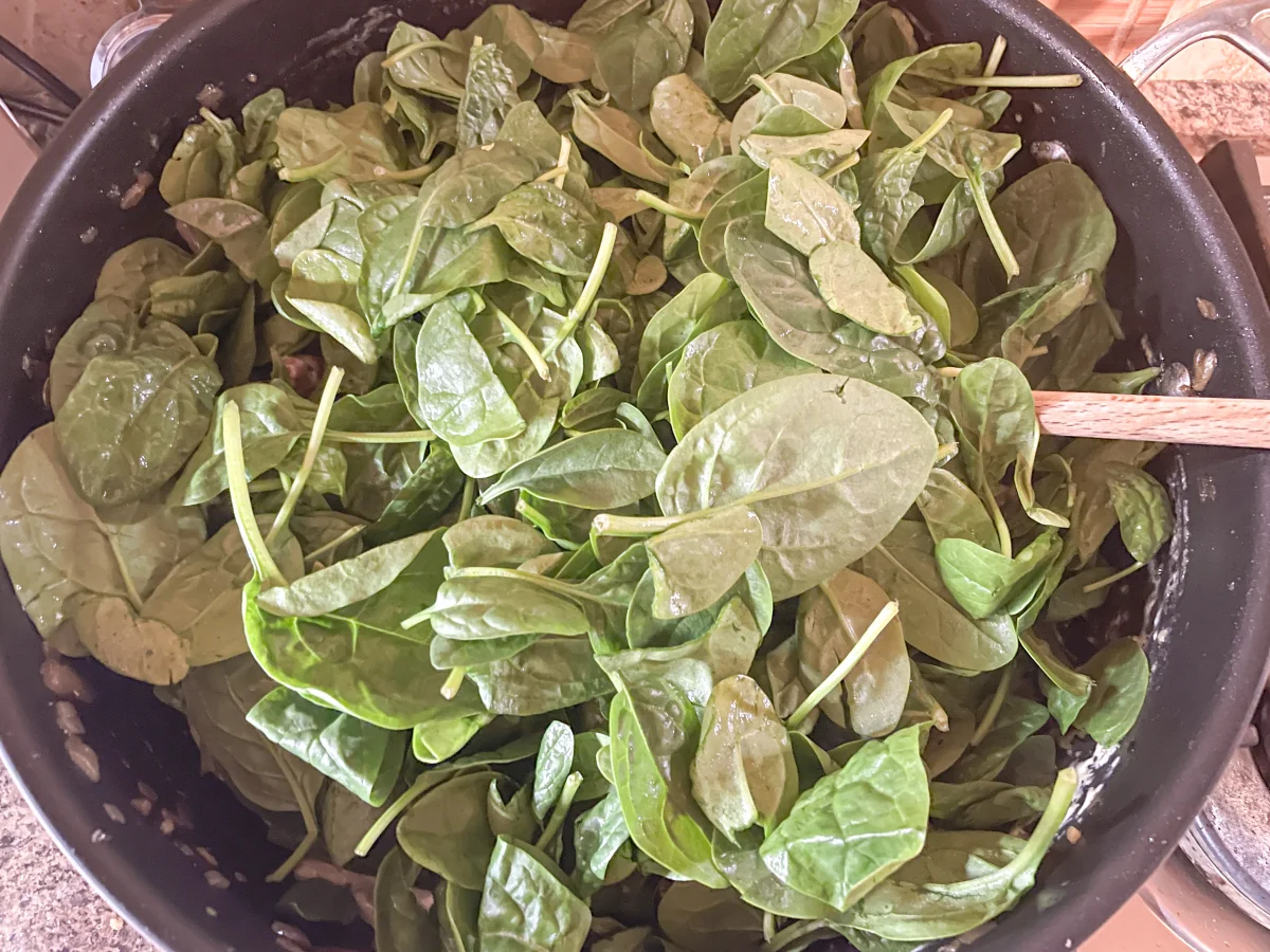 Spinach added to the creamy pasta sauce