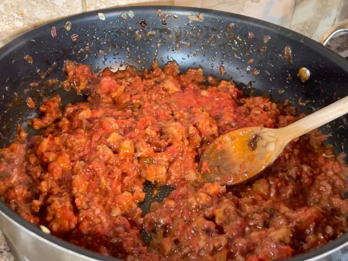 Stirring in the tomatoes for the sausage ragu