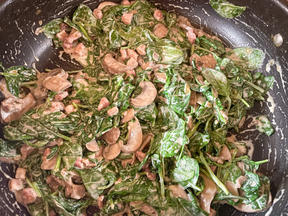 Wilted spinach on the creamy sauce